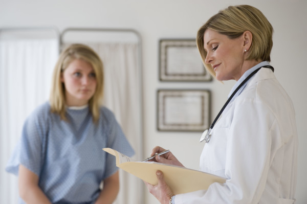 Female doctor reading chart.