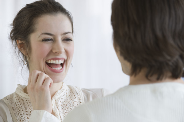 Woman laughing next to boyfriend.