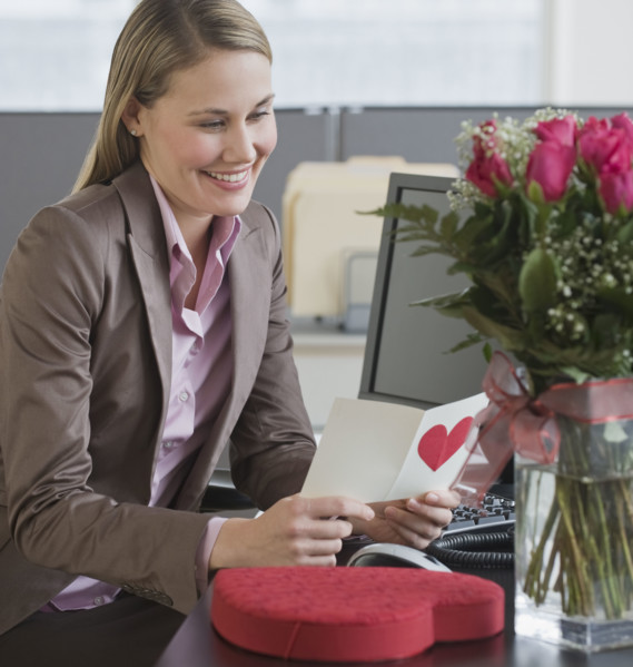 Businesswoman reading Valentine’s Day card.