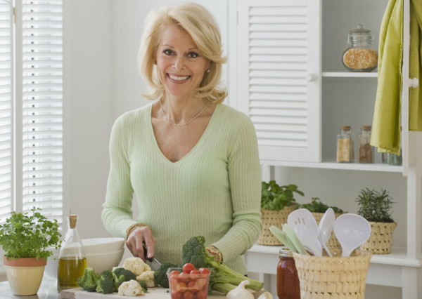 Senior woman chopping vegetables.