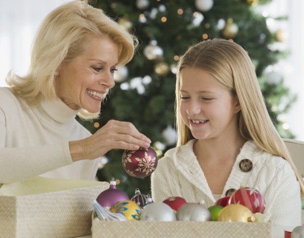 Grandmother and granddaughter looking at Christmas ornaments.