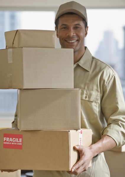 African delivery man carrying stack of packages.
