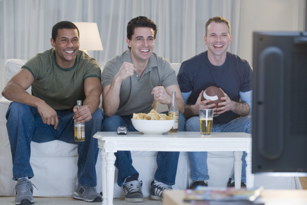 Multi-ethnic men watching sports on television.