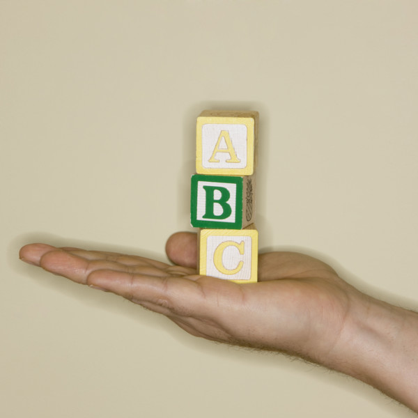 Man holding ABC blocks.