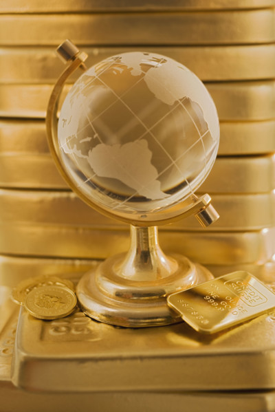 Globe in front of stack of gold bars.