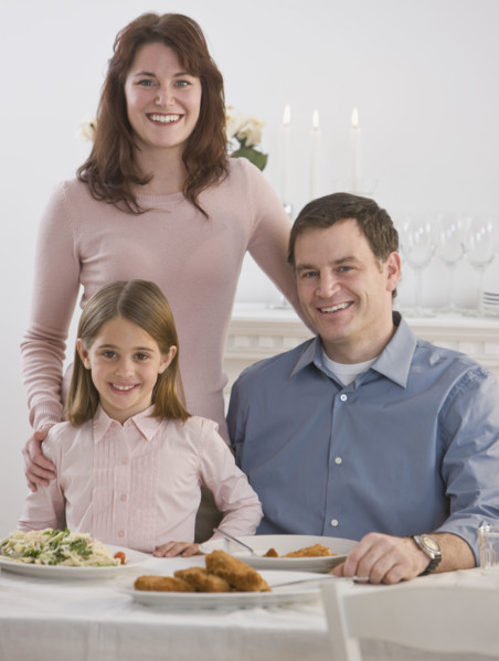 Portrait of family at dinner table.