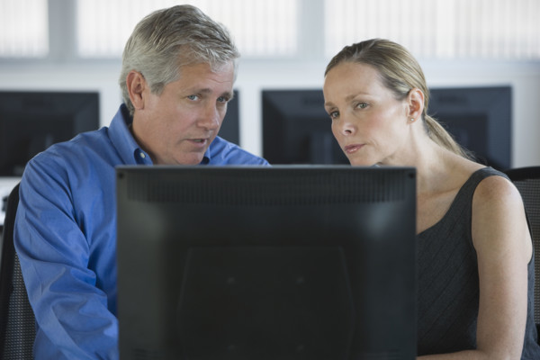 Businesspeople looking at laptop.