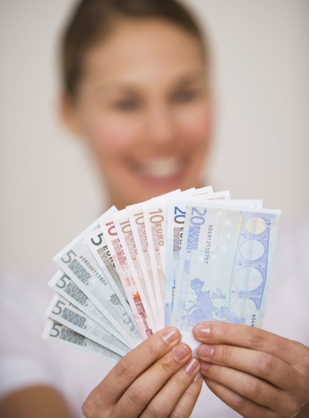 Woman holding fanned out euro banknotes.