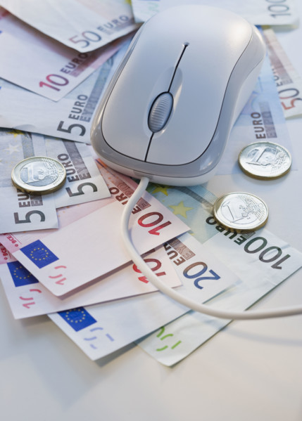 Computer mouse on euro banknotes and coins.