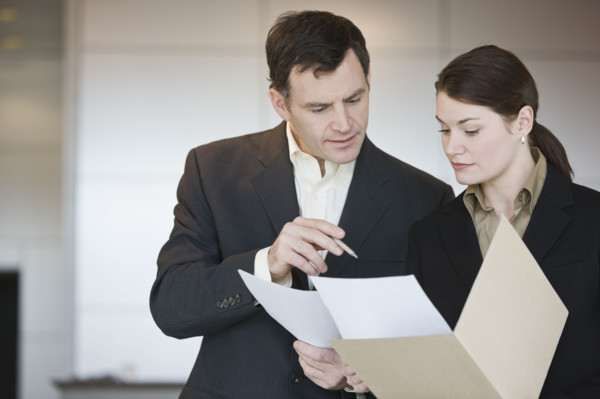 Businesspeople reading looking at paperwork.