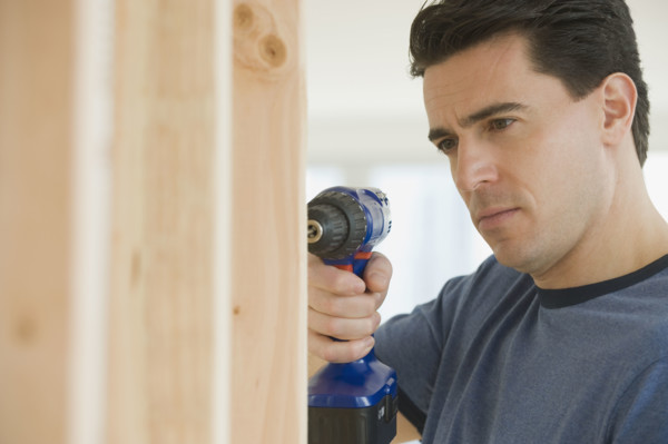 Man using cordless drill.