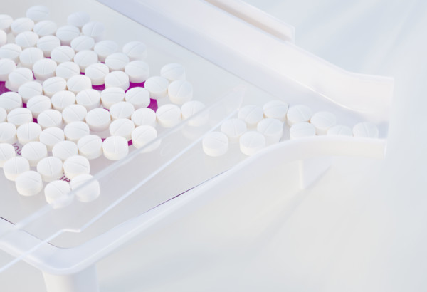 Close up of pills in measuring device.