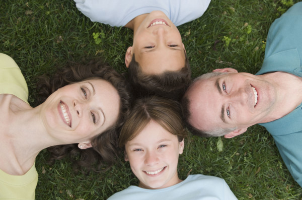 Family with two children laying on grass.