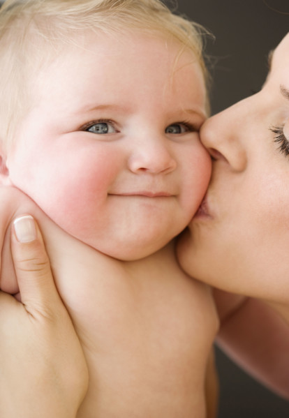 Mother kissing baby’s cheek. Date : 2008