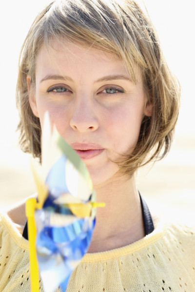Woman blowing on pinwheel. Date : 2008