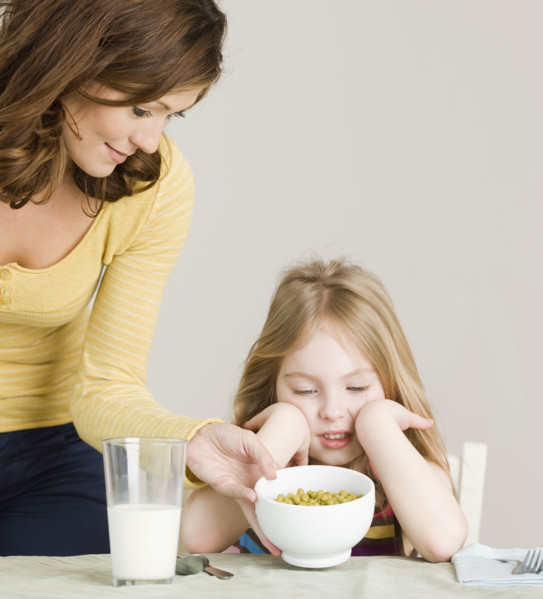 Mother serving vegetables to daughter. Date : 2008