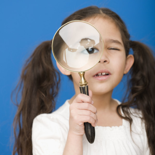 Hispanic girl looking through magnifying glass. Date : 2008
