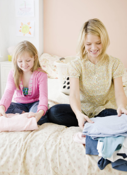 Mother and daughter folding clothing. Date : 2008
