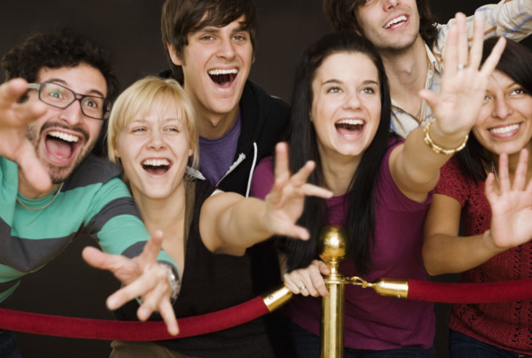 Group of people reaching across velvet rope. Date : 2008