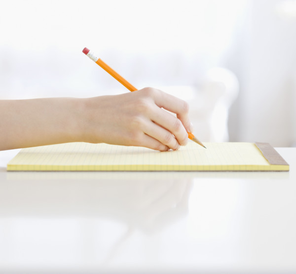 Woman writing on notepad. Date : 2008