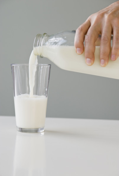 Man pouring milk into glass.