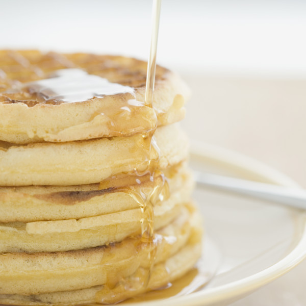 Close up of syrup pouring on waffles. Date : 2008