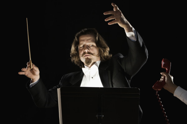 Telephone being handed to orchestral conductor. Date : 2008