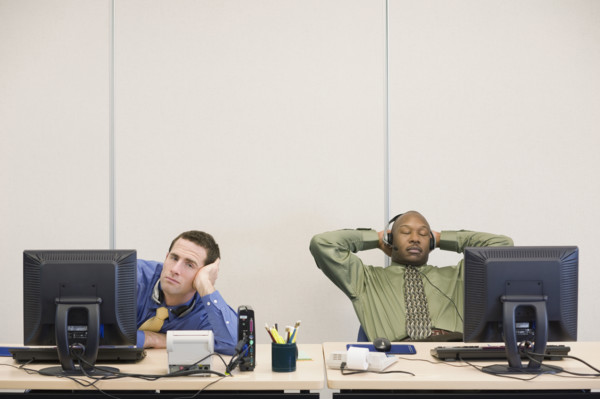 Multi-ethnic businessmen sitting at desks. Date : 2008