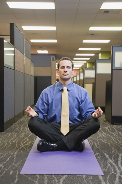 Businessman meditating in office. Date : 2008