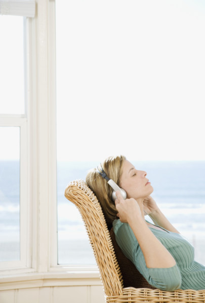Woman listening to headphones. Date : 2008