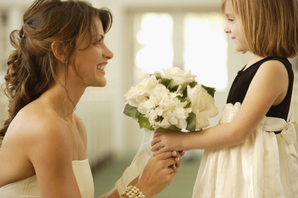 Bride handing bouquet to flower girl. Date : 2008