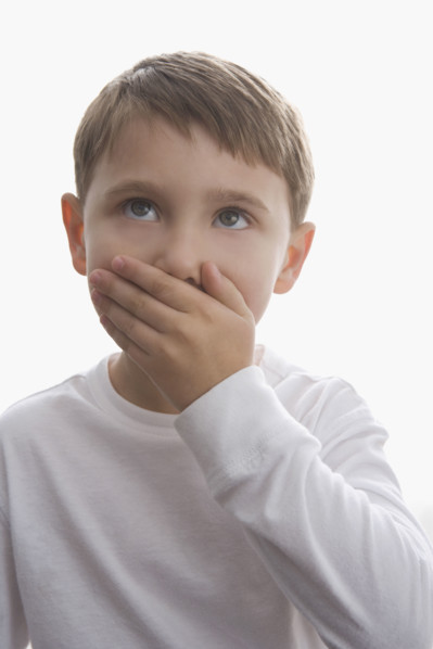 Boy covering mouth with hand. Date : 2008