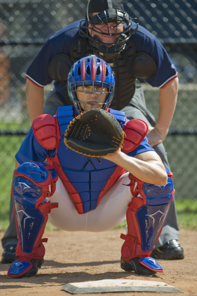 Baseball pitcher and umpire in ready position.