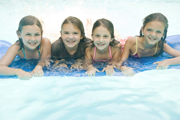Girls resting on inflatable raft in swimming pool. Date : 2008