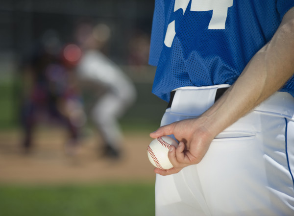 Baseball pitcher preparing to pitch ball.