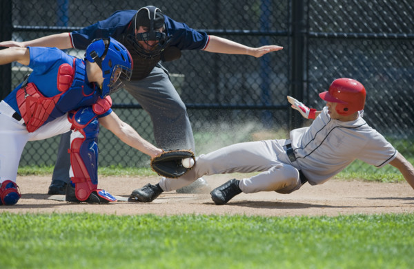 Baseball player sliding into home plate.