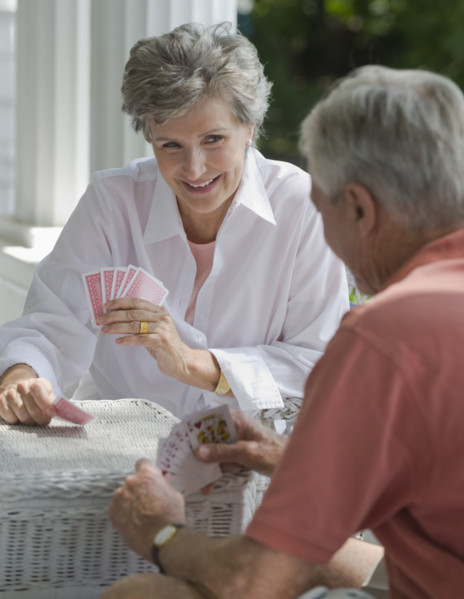 Senior couple playing card game on porch.