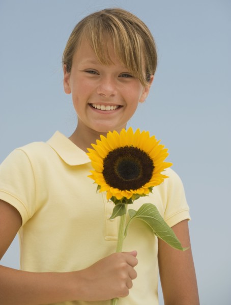 Girl holding sunflower.