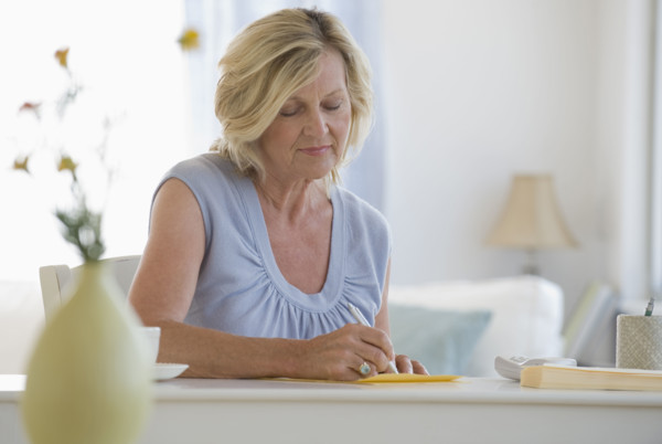 Woman writing letter at home.