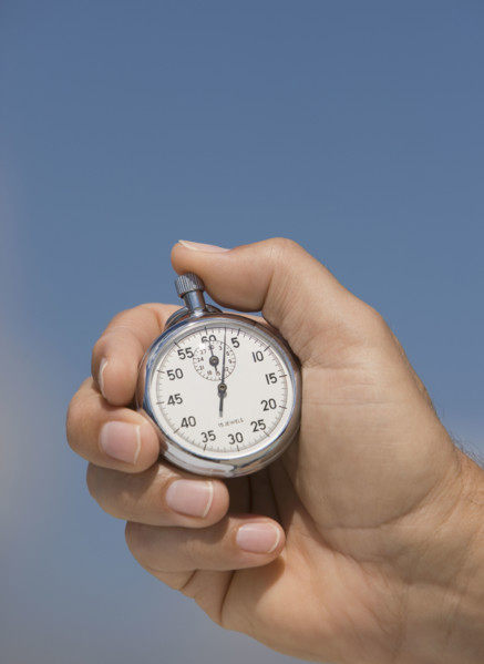 Close up of hand holding stopwatch.