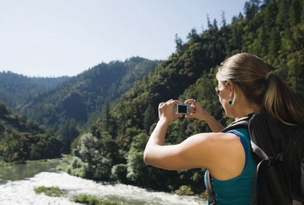 Hiker photographing river scene. Date : 2008