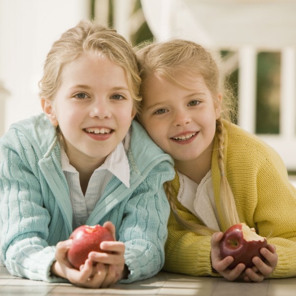 Sisters eating apple on porch. Date : 2008
