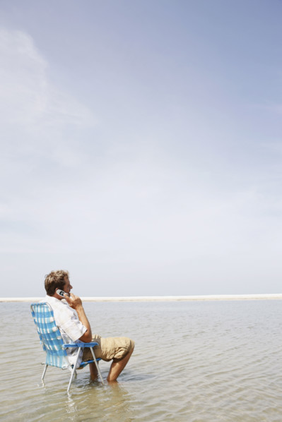 Man talking on cell phone in middle of water. Date : 2008