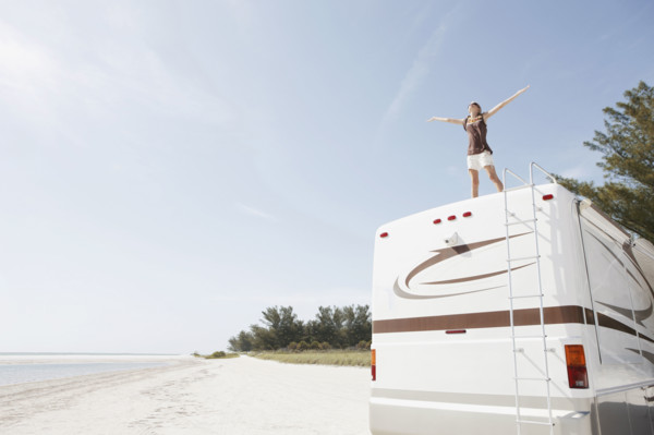 Young woman standing on top of motor home. Date : 2008