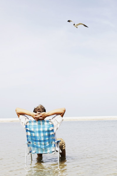 Man relaxing in lounge chair in middle of water. Date : 2008