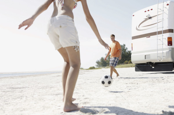 Young couple playing soccer on beach. Date : 2008