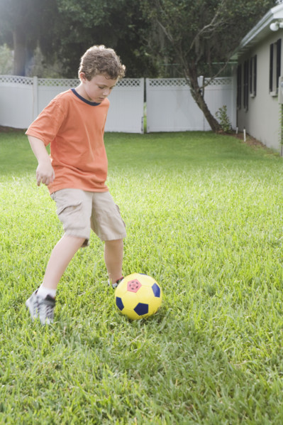 Boy playing in soccer in backyard. Date : 2008