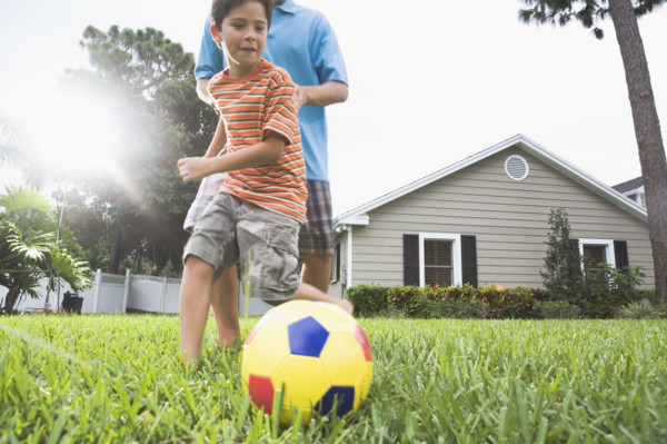 Father and son playing soccer in backyard. Date : 2008