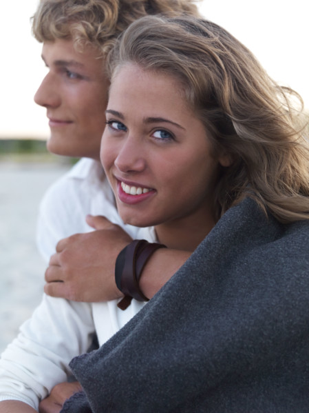Young couple wrapped in blankets on beach. Date : 2008