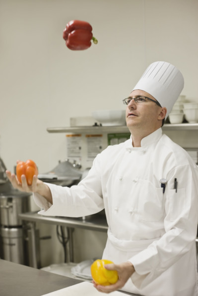 Chef juggling assorted peppers. Date : 2008
